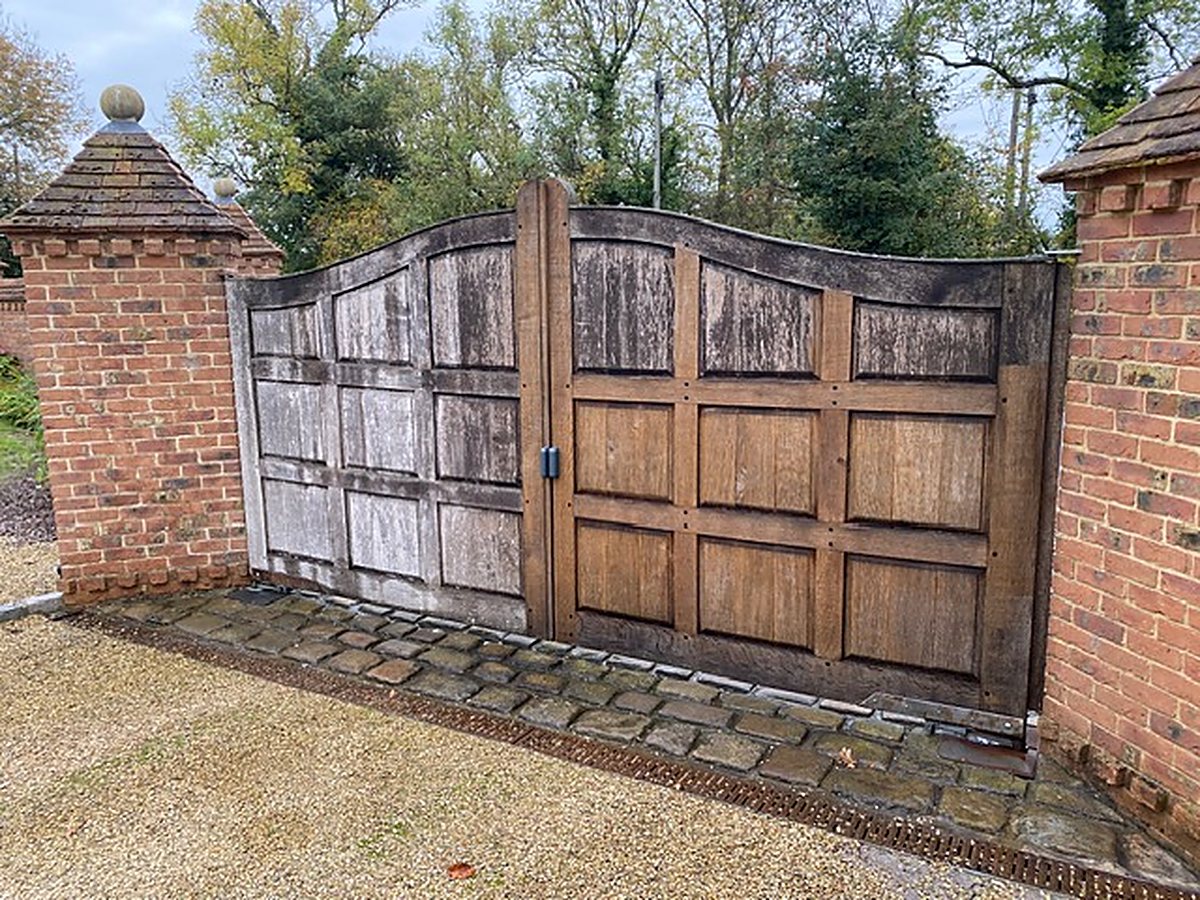 Timber entrance gates between brick piers on a property looked after by SJT Garden & Property Maintenance